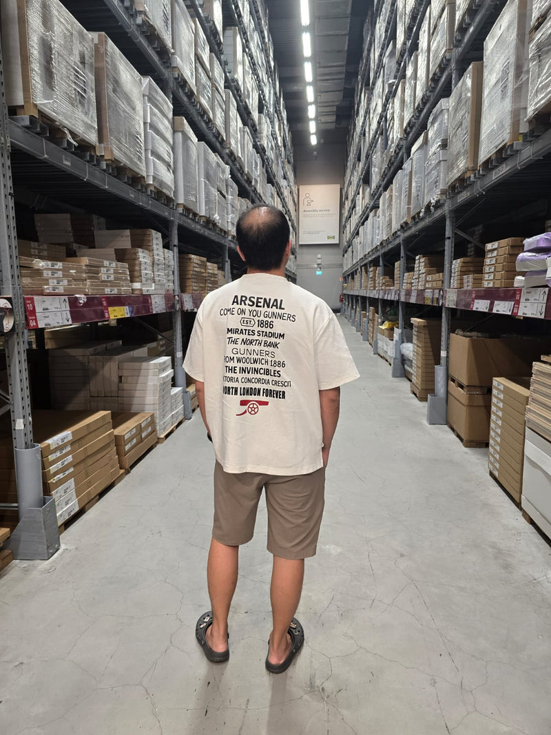 Person wearing an Arsenal t-shirt in a warehouse setting