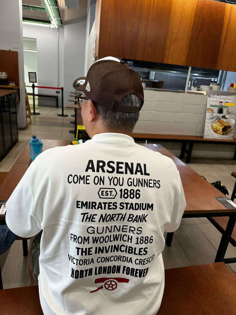 Person wearing an Arsenal Perfect10 shirt in a casual setting