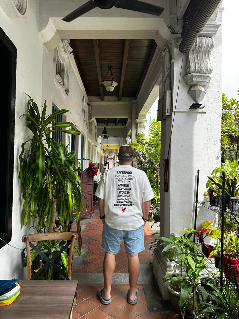 Person Liverpool Perfect10 at a garden path with plants and a building in the background